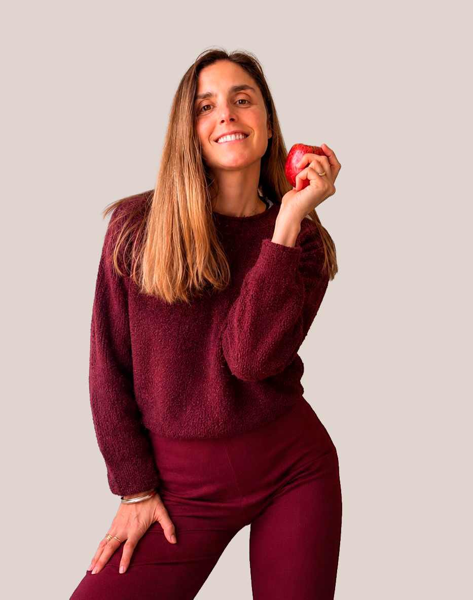 Talia Alles sonriendo y sosteniendo una manzana